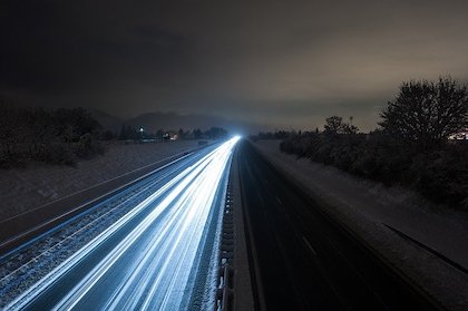 Highway at night with time-lapsed lights.